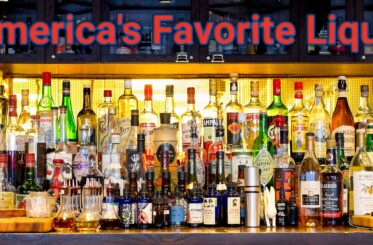 Various liquor bottles on a bar. "America's Favorite Liquor"