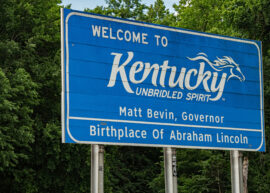 Blue sign with white lettering that reads: "Welcome to Kentucky Unbridled Spirit"