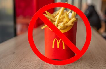 Large McDonald's Fries on a counter with a "no" sign over them.