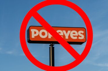 Popeye's sign with a "no" sign in front of it.