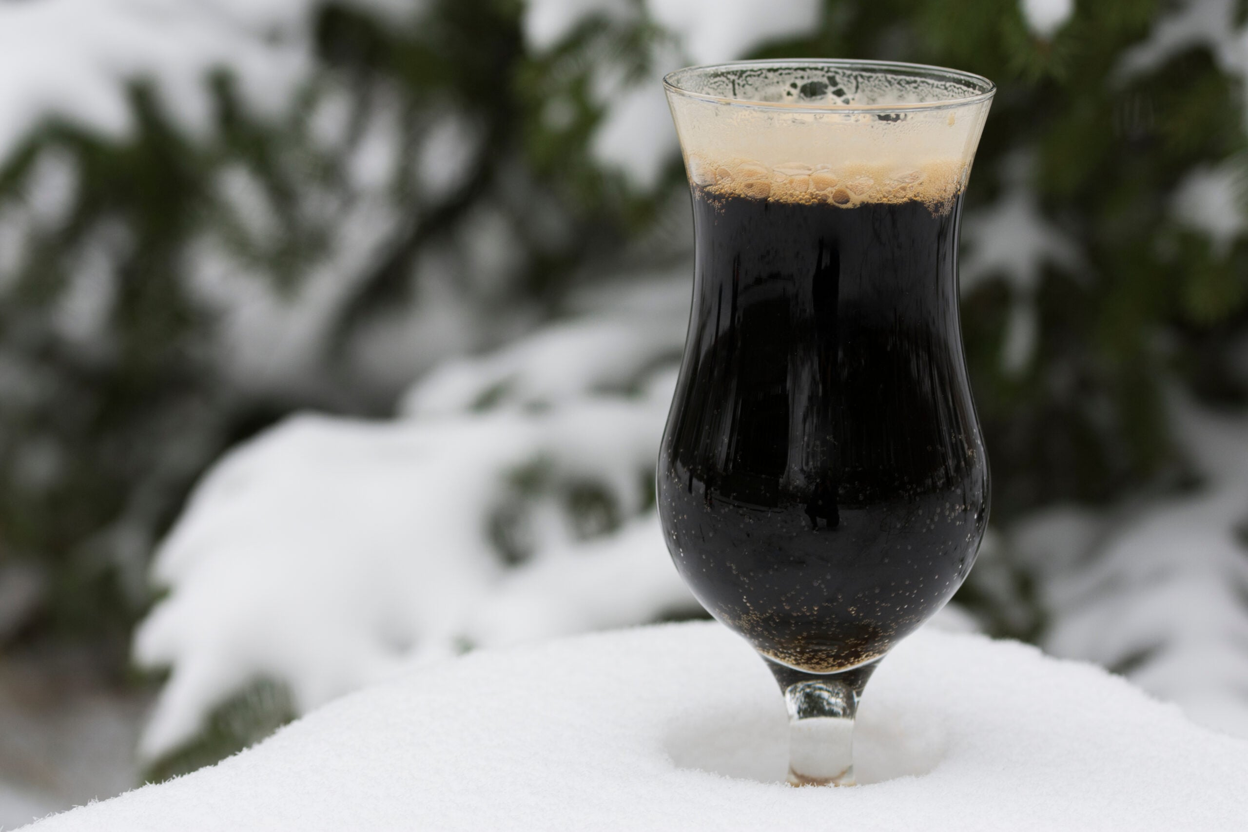 A pint of Imperial Stout beer on a winter background. 