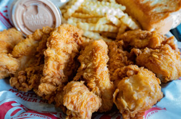 Raising Cane's chicken fingers and crinkle-cut fries in a basket