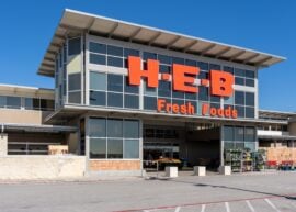 sign for "H-E-B Fresh Foods" on the front of a grocery store