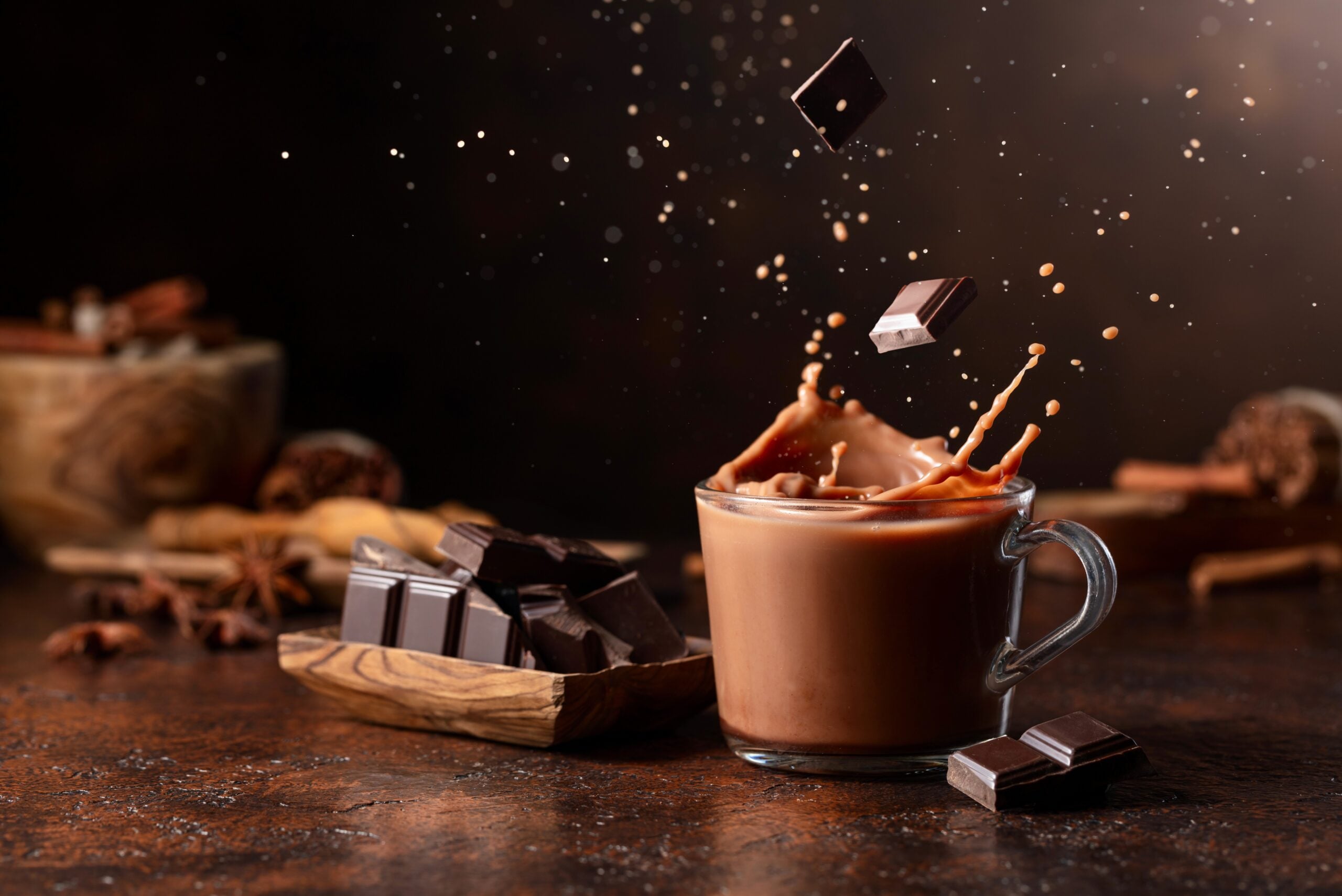 Dark chocolate falling into a cup of hot chocolate. 