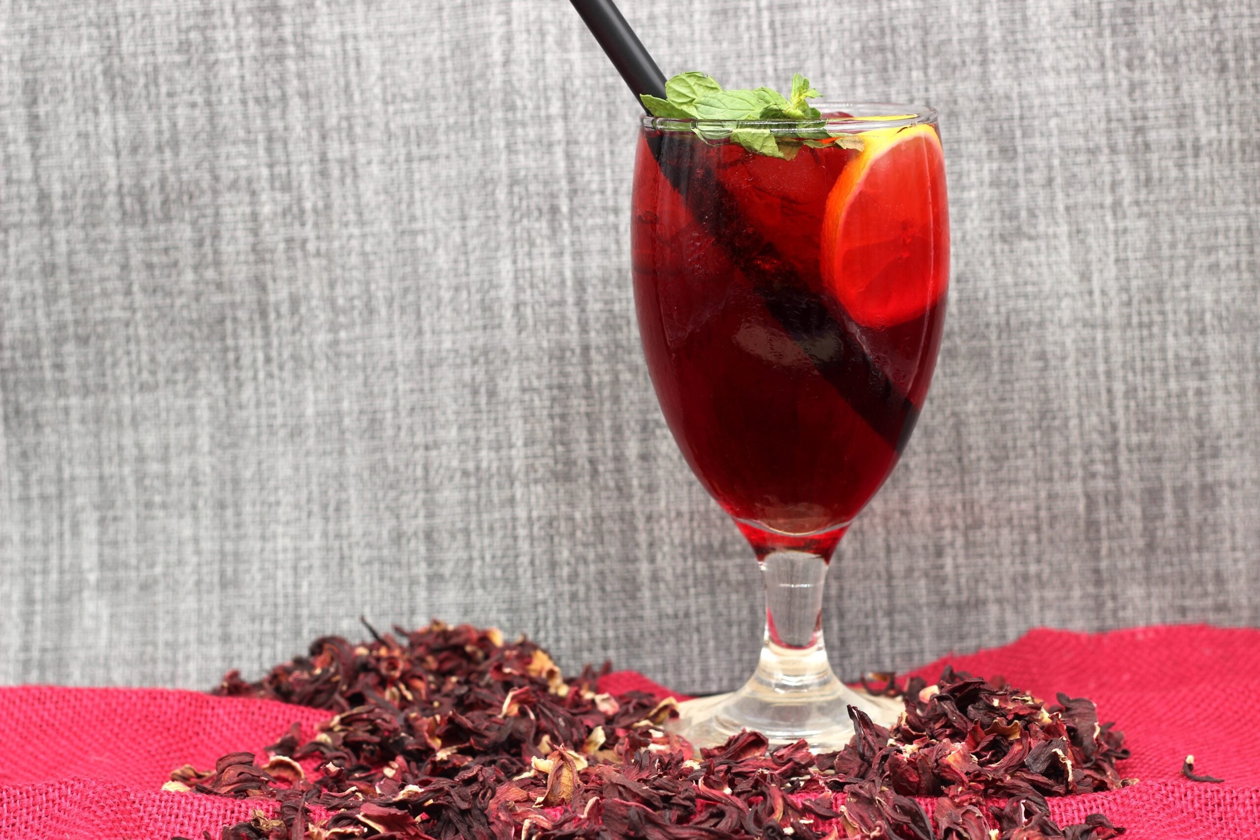 A refreshing hibiscus lemonade encircled by dried hibiscus petals. 