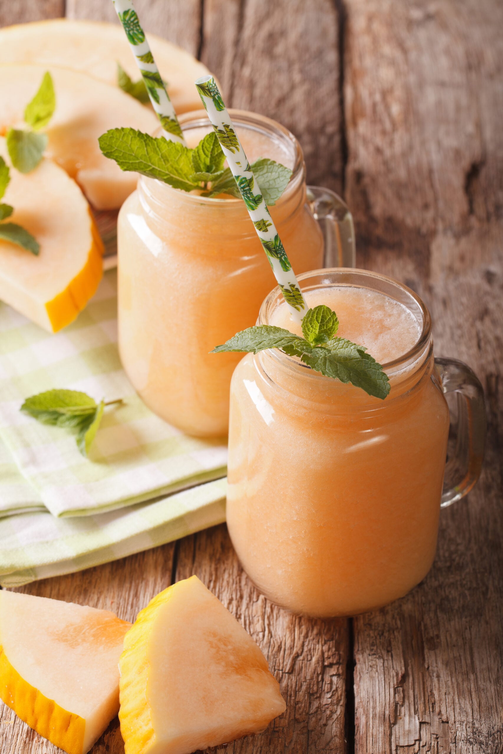 Delicious honeydew melon smoothies on a wooden background. 