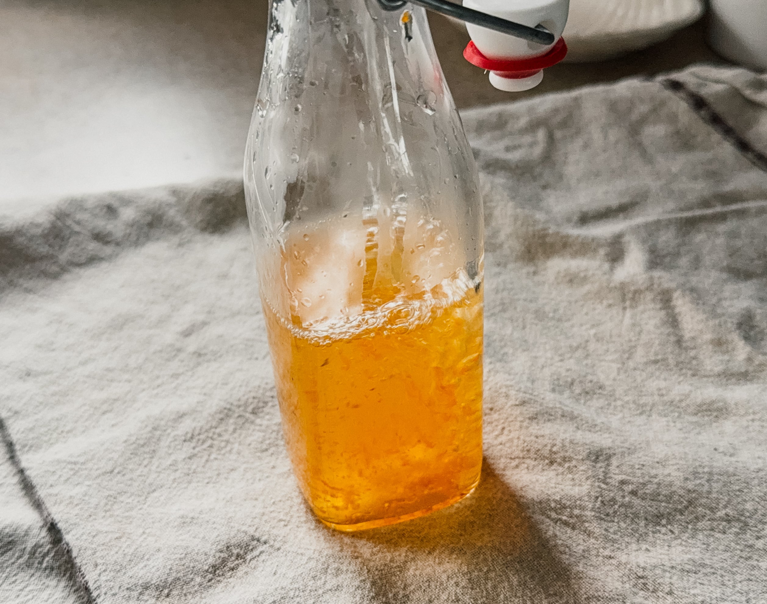 Water being added to a bottle with turmeric and apple cider vinegar.