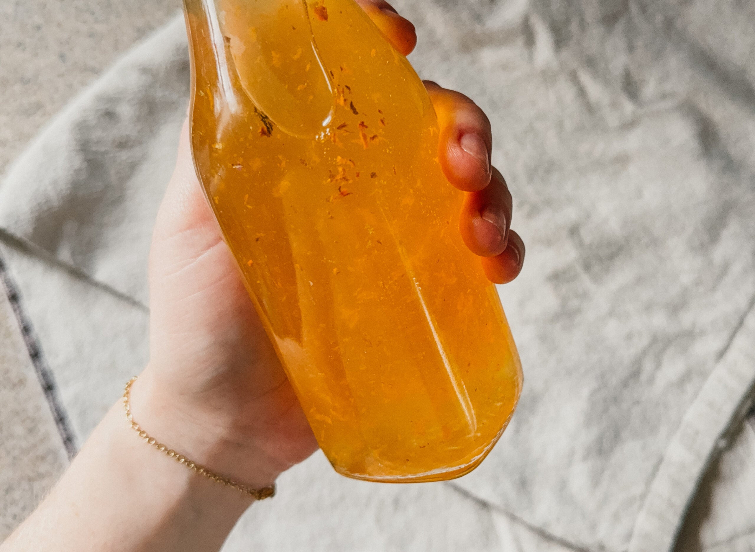 A hand holding a bottle of turmeric and apple cider vinegar.