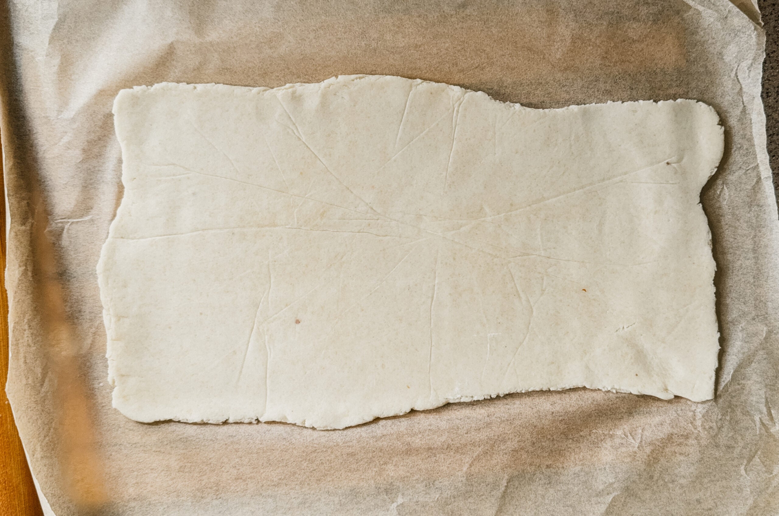 A rectangle of dough on top of parchment paper.