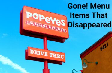 Popeyes Louisiana Kitchen drive-thru sign against blue sky.
