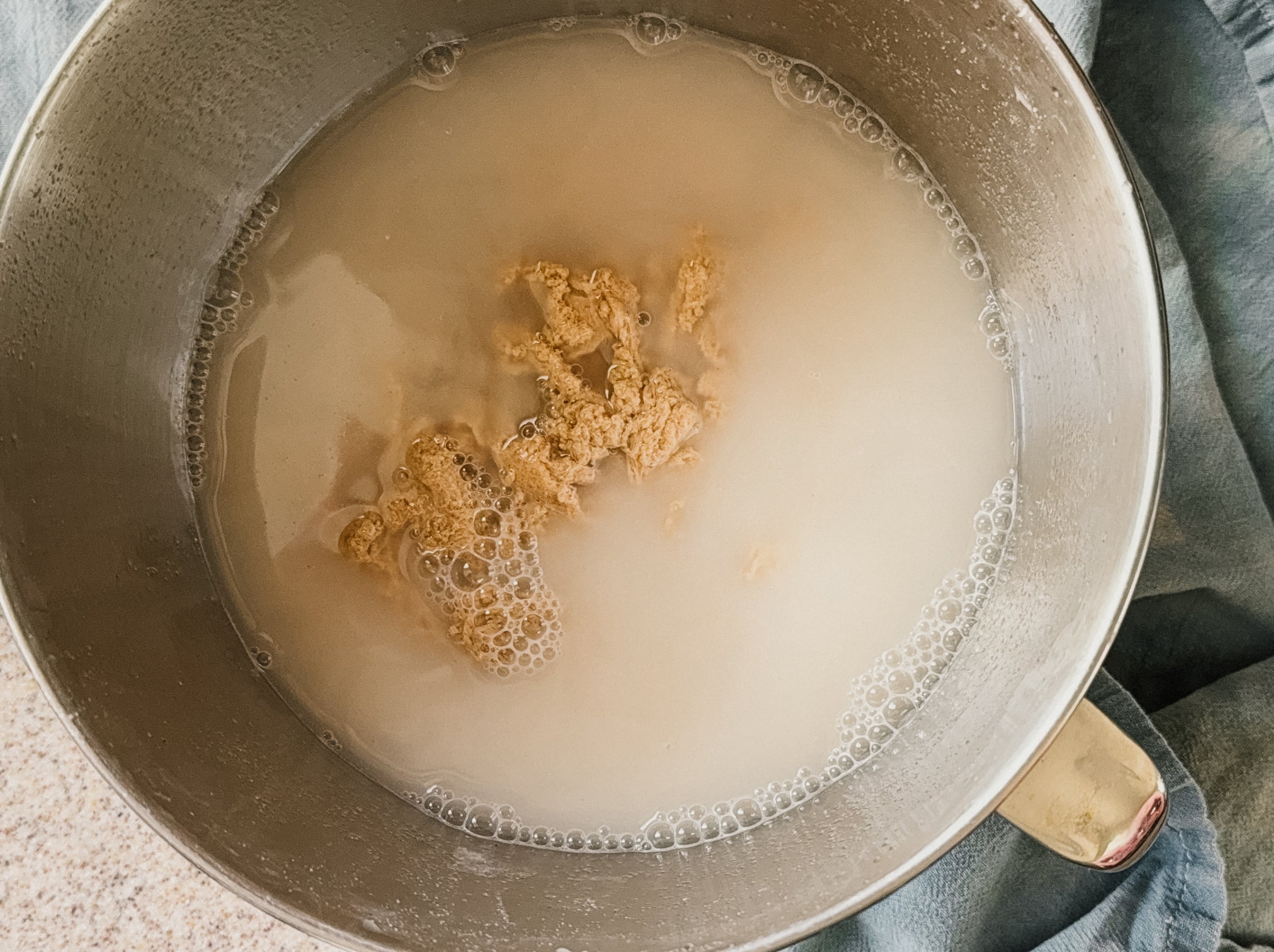 A dough ball after being kneaded in a bowl full of starchy, cloudy water.