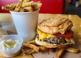 Five Guys fries with a cheeseburger and mayo...all on a table top.