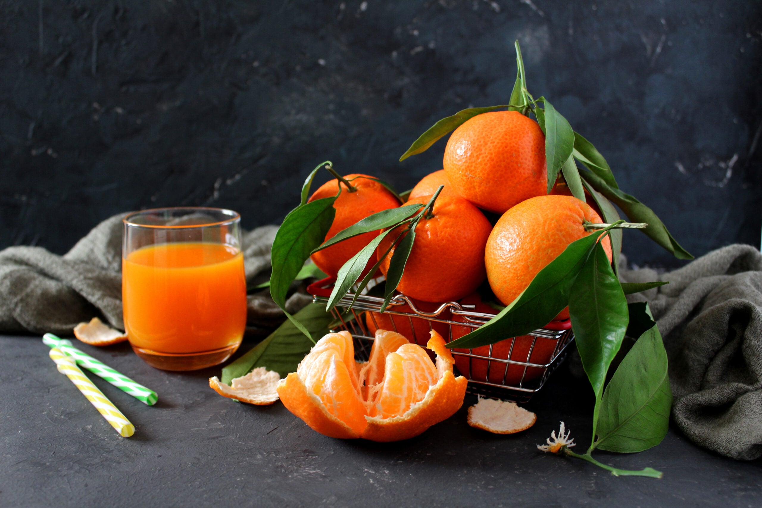 A freshly made tangerine juice, surrounded by ripe tangerines. 