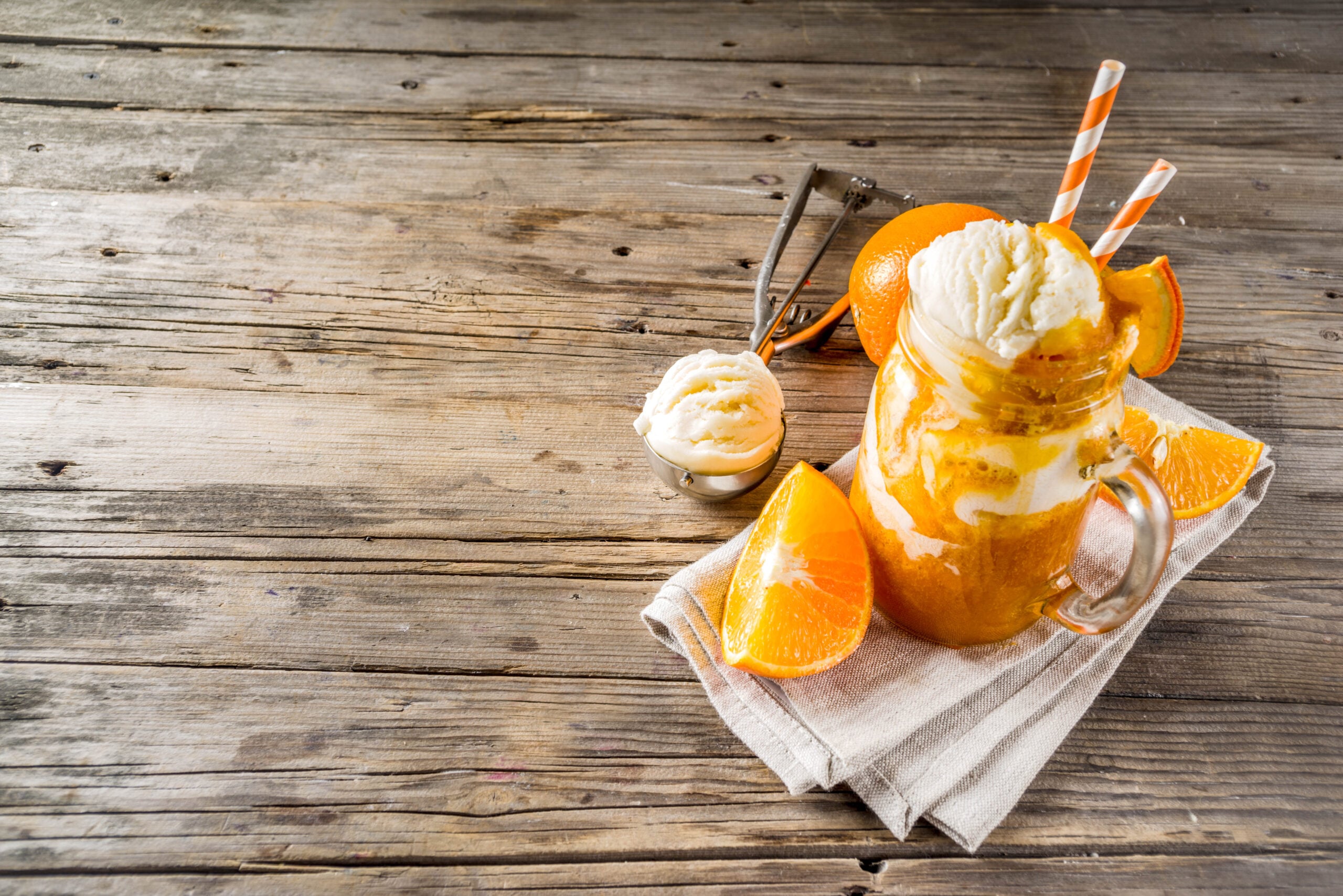 Aerial view of a wooden surface showing a tasty orange cream soda.