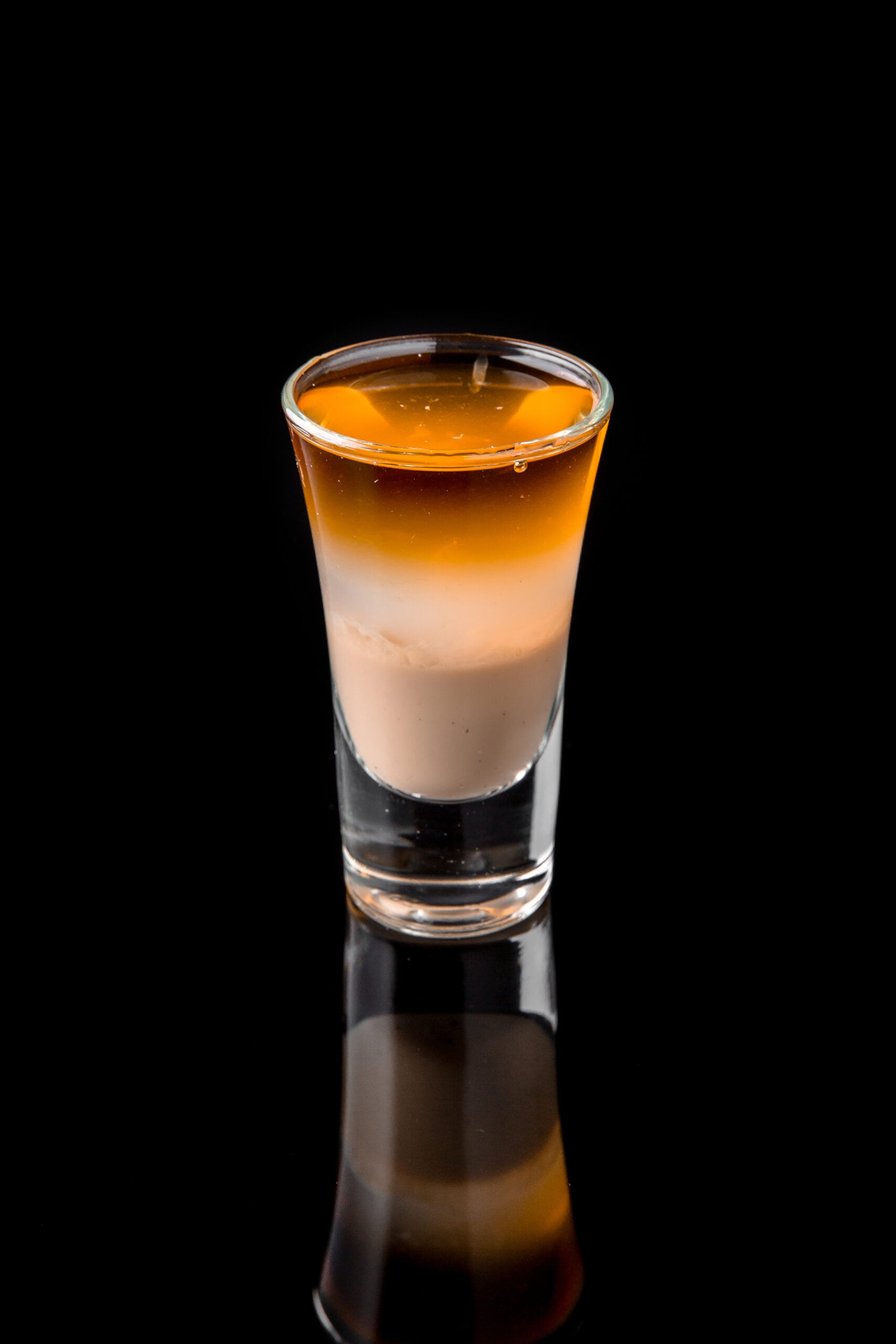 A single glass of Nutty Irishman shot on a black background.
