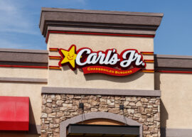 Carl's Jr. logo on building exterior with stone facade.