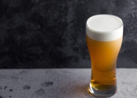 Glass of beer on a table with a black background
