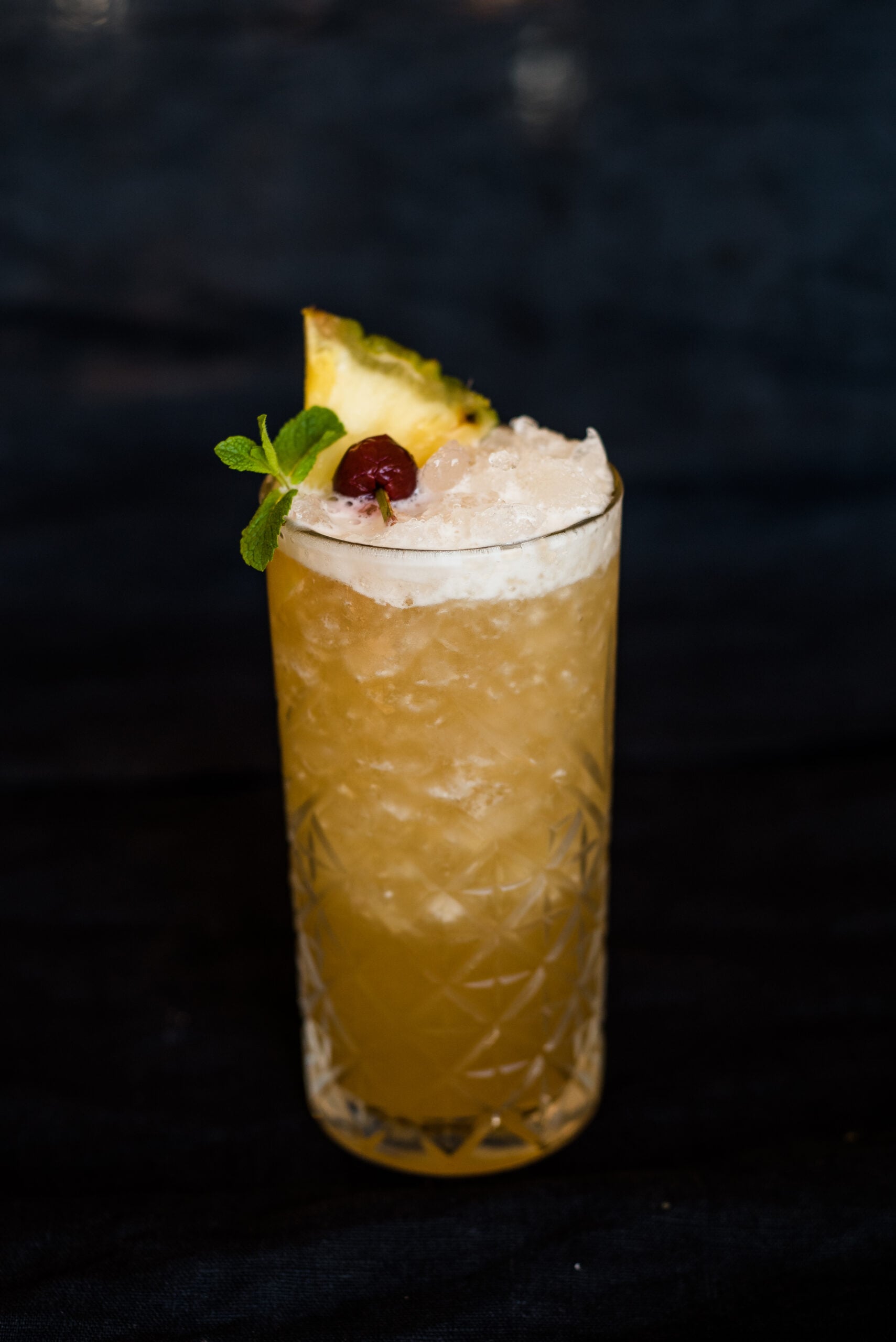 A black backdrop featuring a glass full of nightcup drink. 