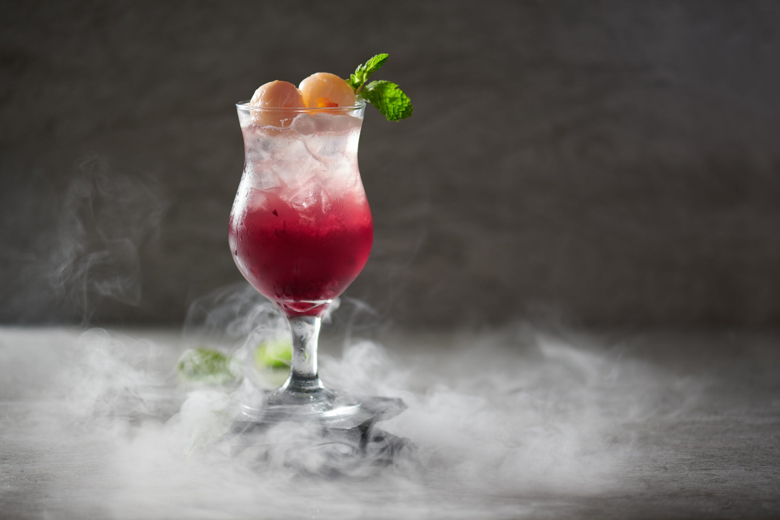 A frozen purple rain cocktail against a dark backdrop. 