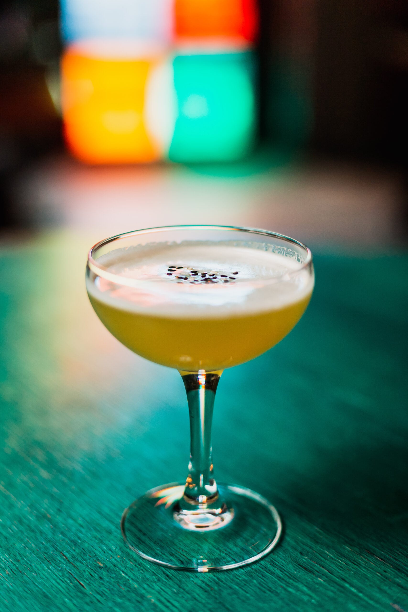 A macro shot of a single glass of quince sour. 
