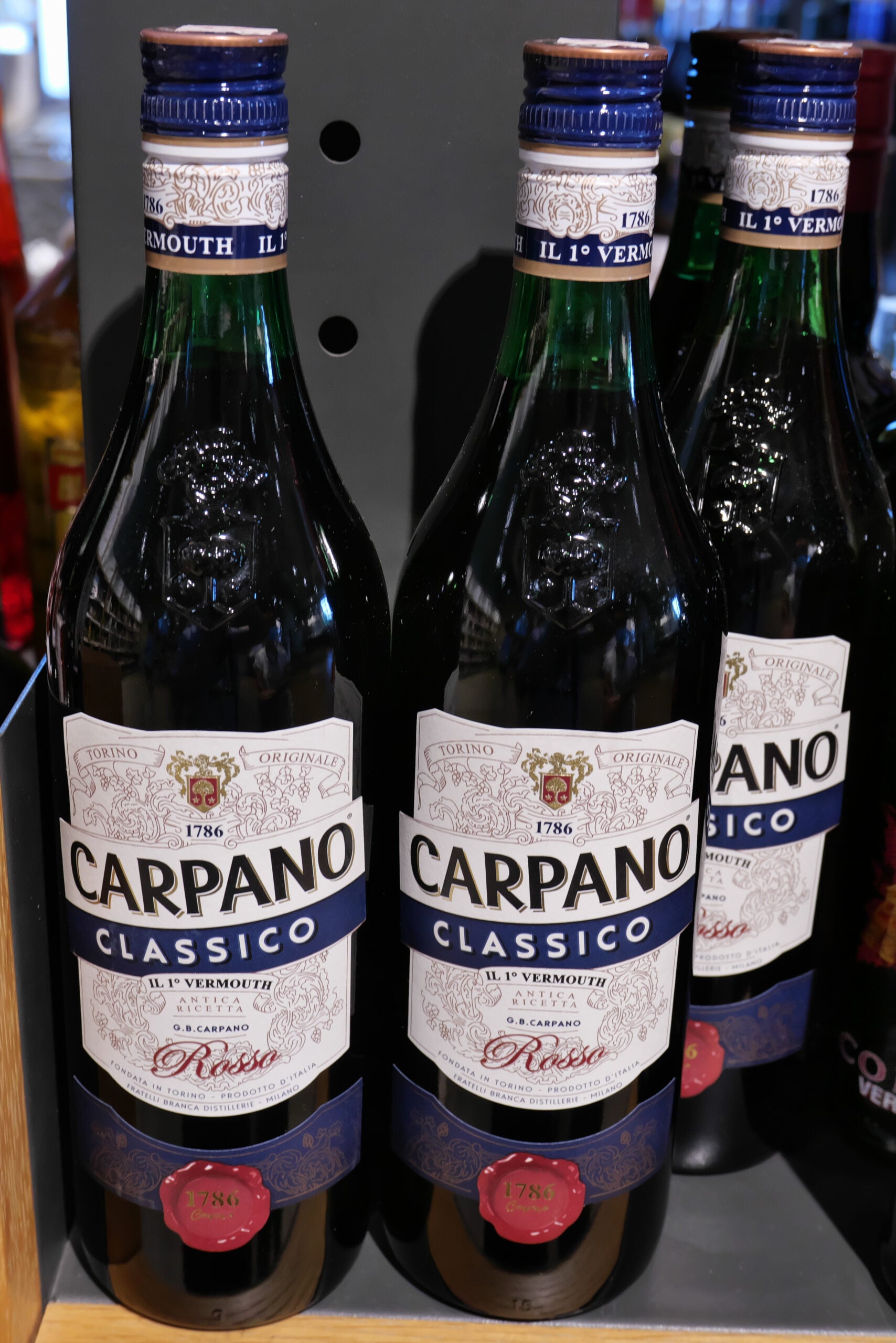 A few bottles of traditional Italian Carpano Vermouth on a grocery shelf. 