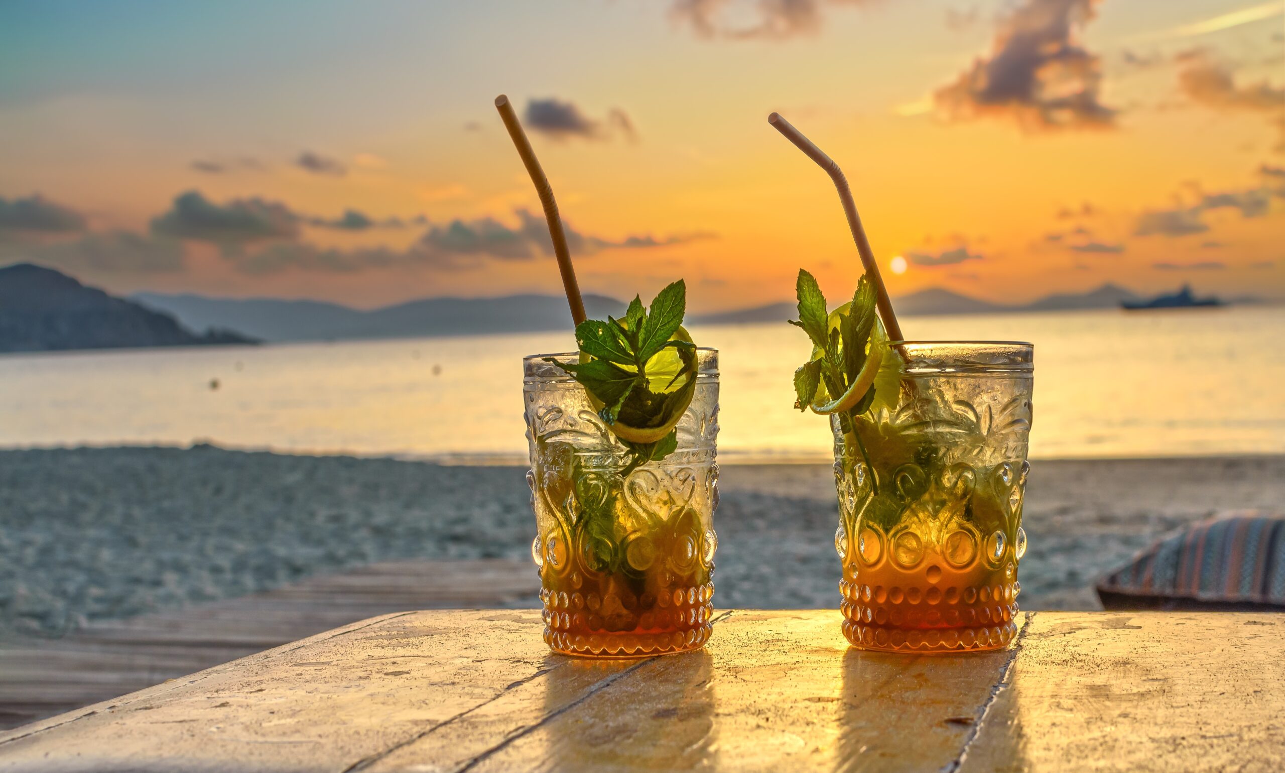Two glasses of rum with lime on a beach landscape. 