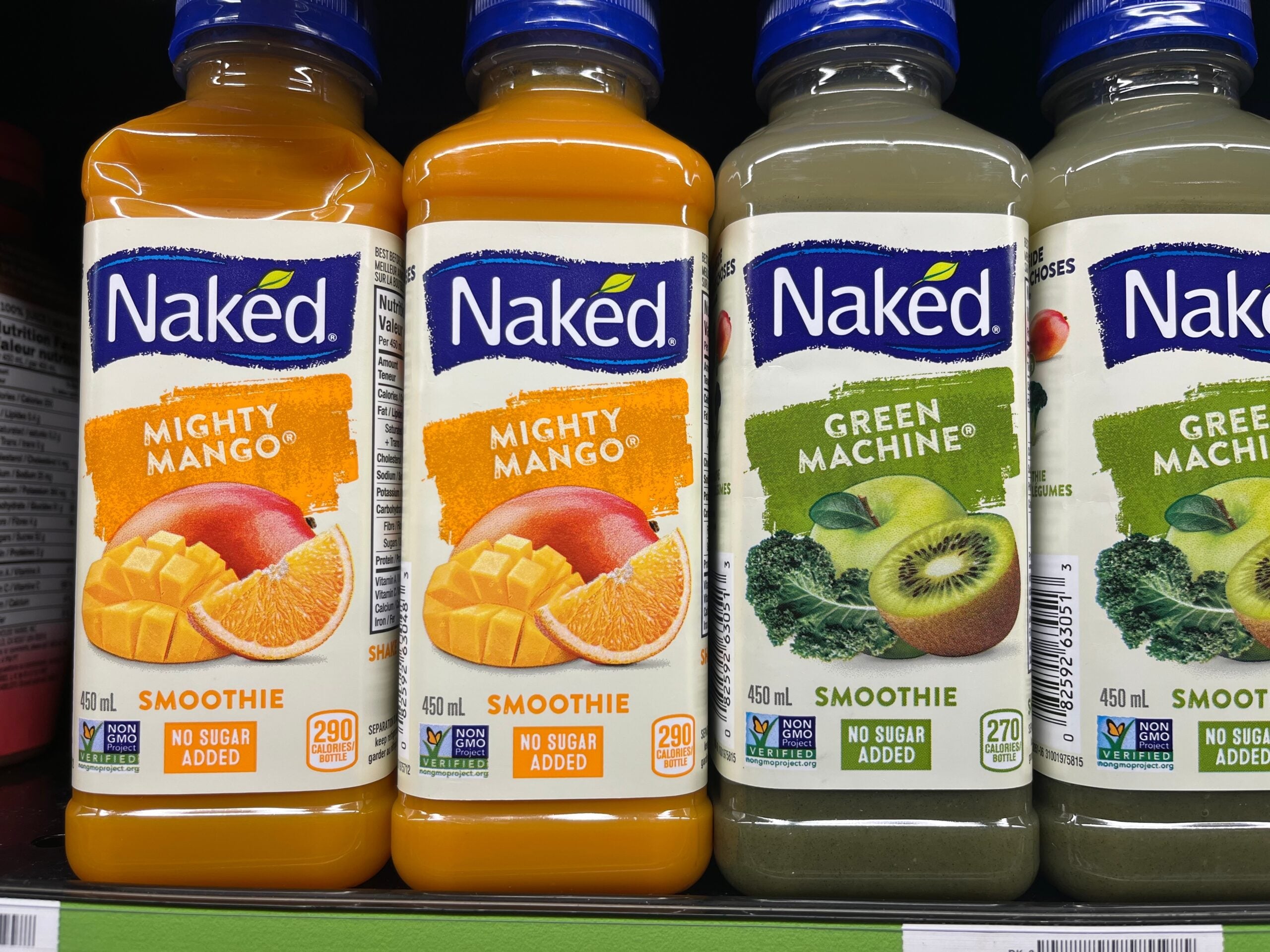 Some Naked juice bottles on a supermarket shelf.