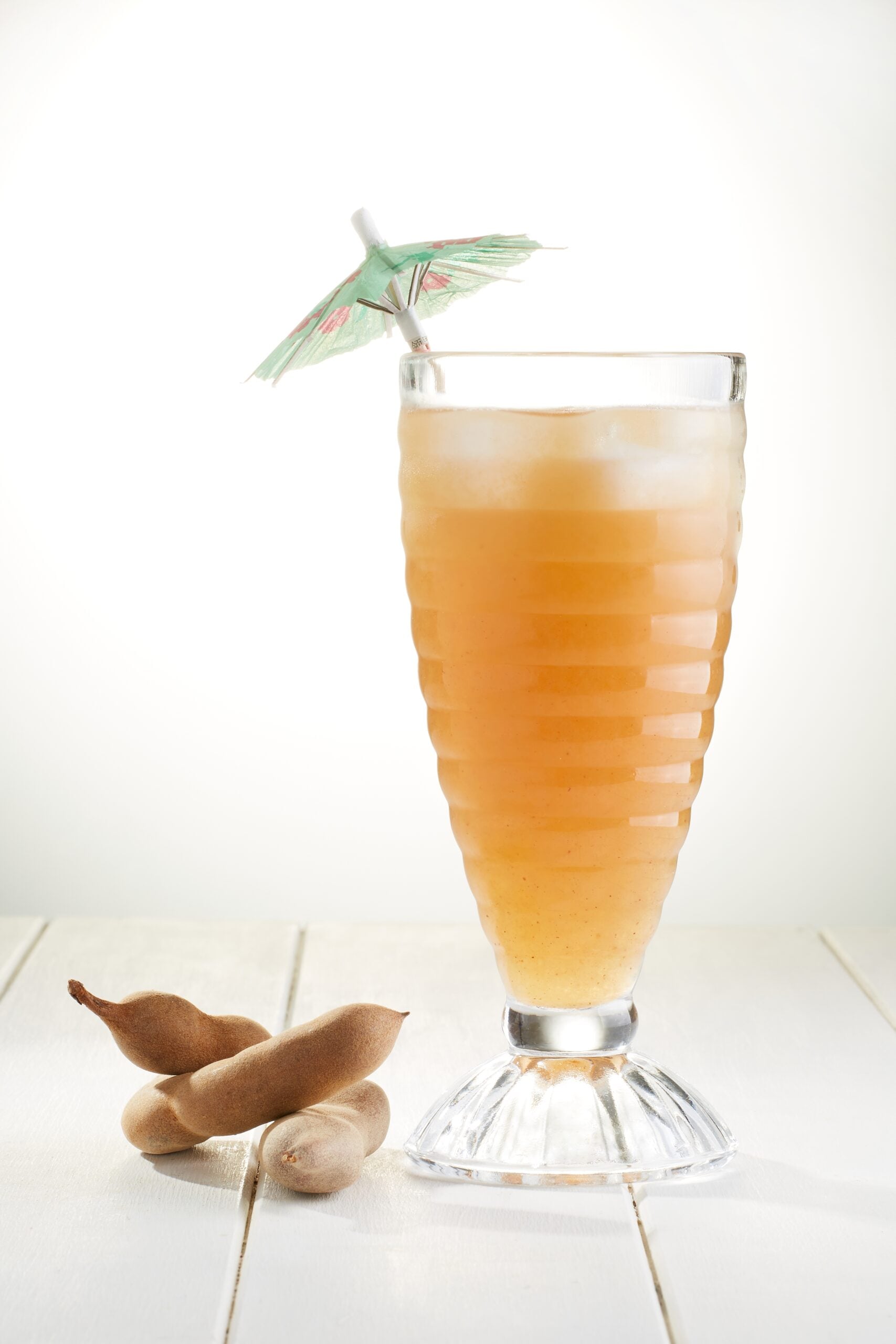 A refreshing tamarind agua fresca, accompanied by a few tamarinds. 