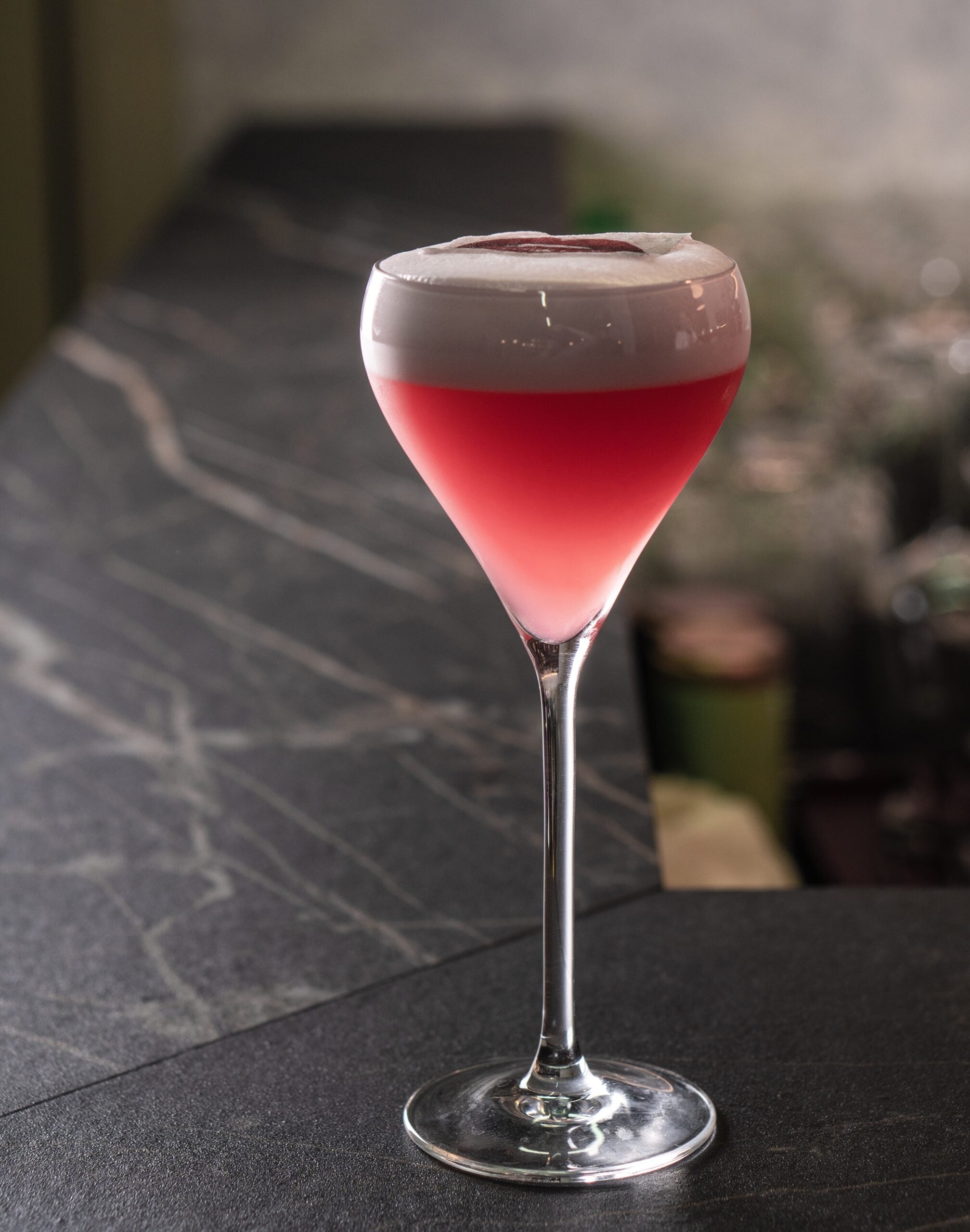 A macro shot of a glass of rasperry sour. 