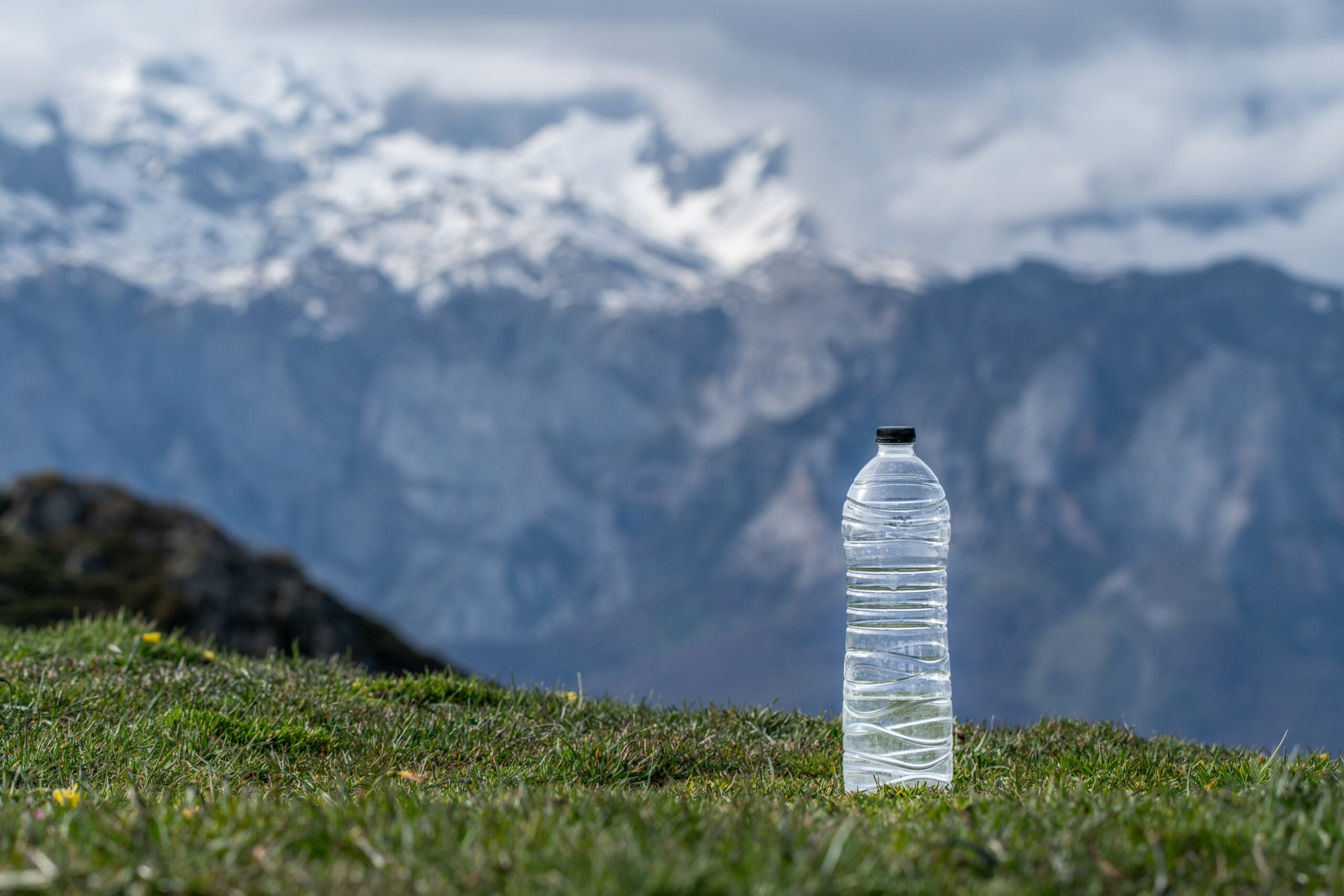 A bottle of natural mineral water in a mountain landscape.