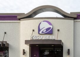 Exterior of Taco Bell with logo and hiring sign.