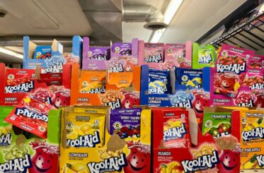 Various Kool-Aid drink packets in colorful boxes on a store shelf.