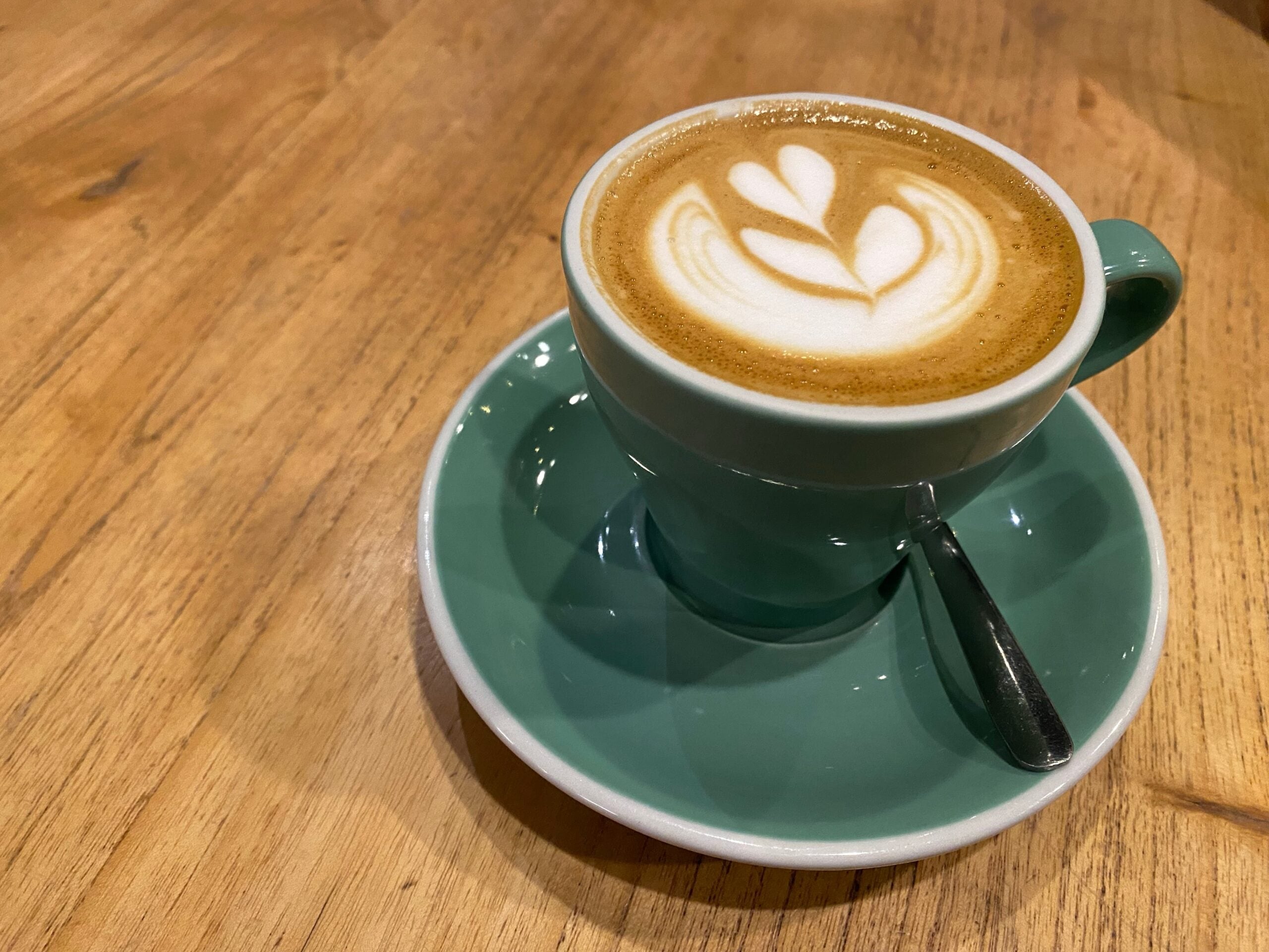 A beautiful crafted cup of magic coffeee on a wooden table. 