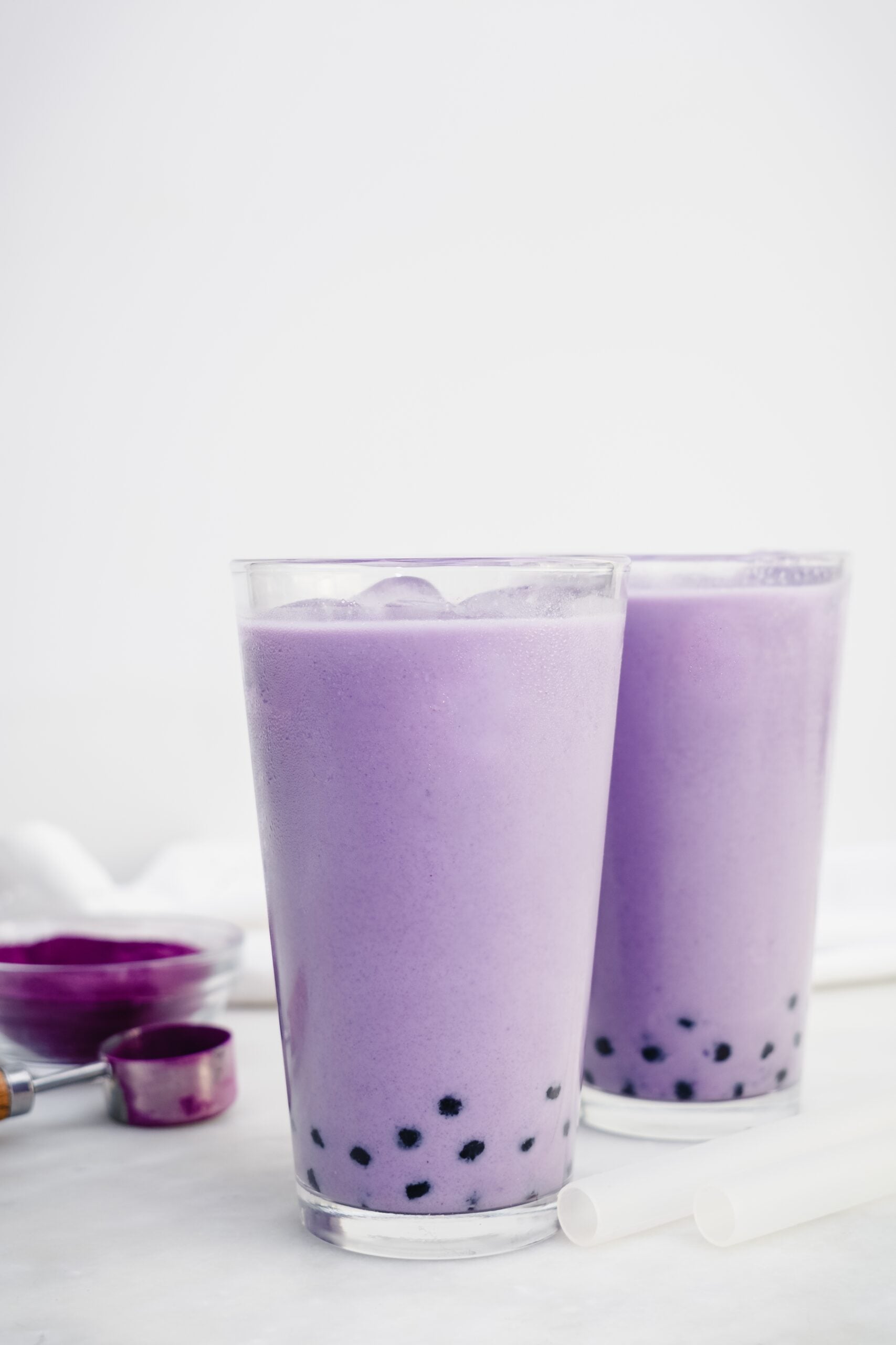 Freshly prepared ube bubble teas on a marble table. 