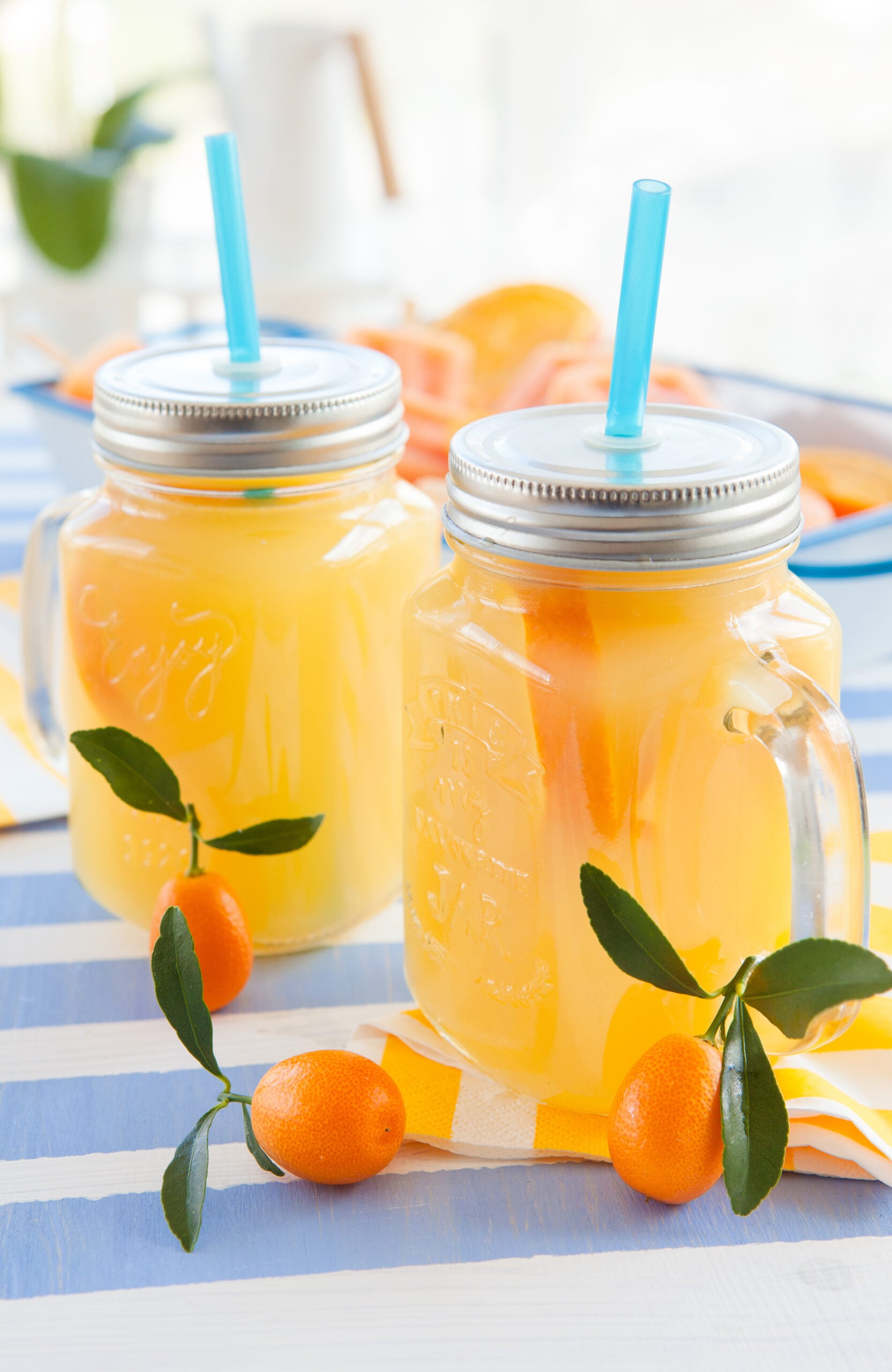 A macro shot of two mugs full of  kumquat juice.