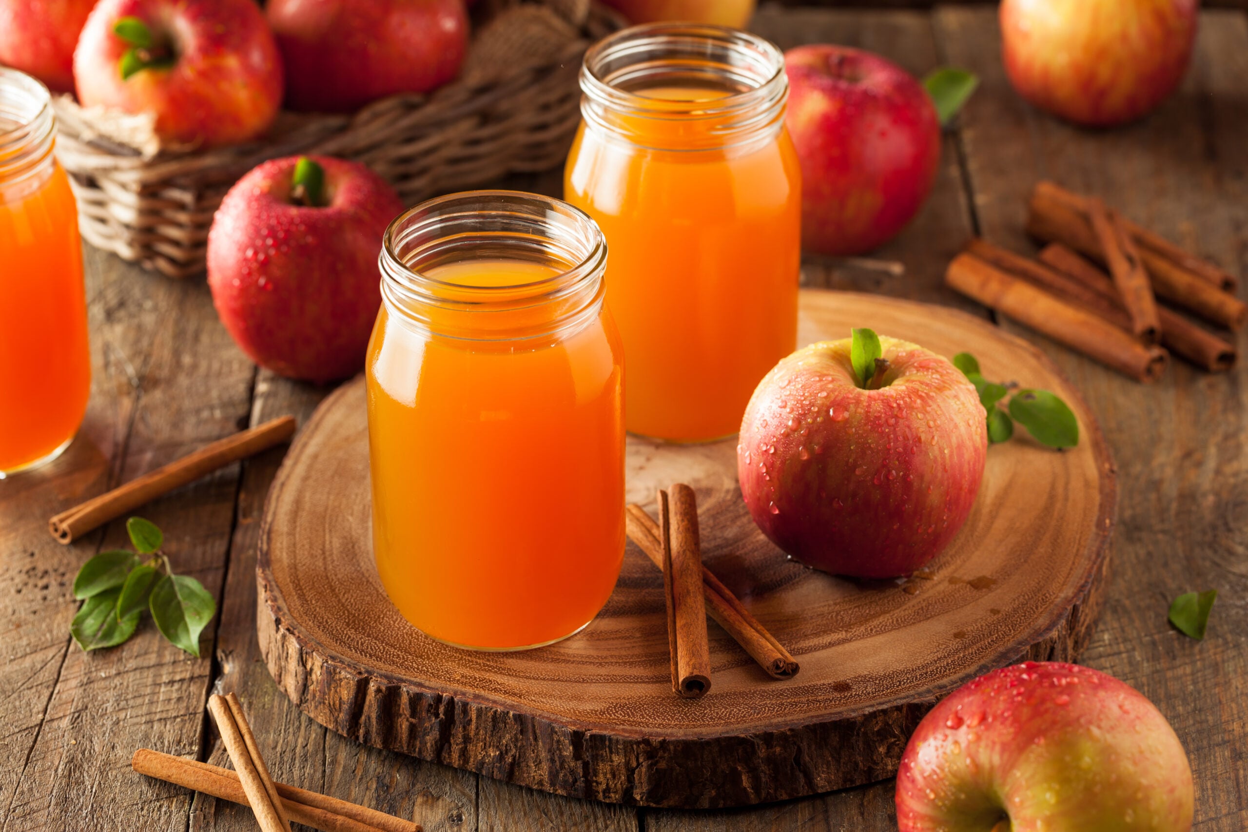 A wooden backdrop showing homemade unfiltered organic apple cider.