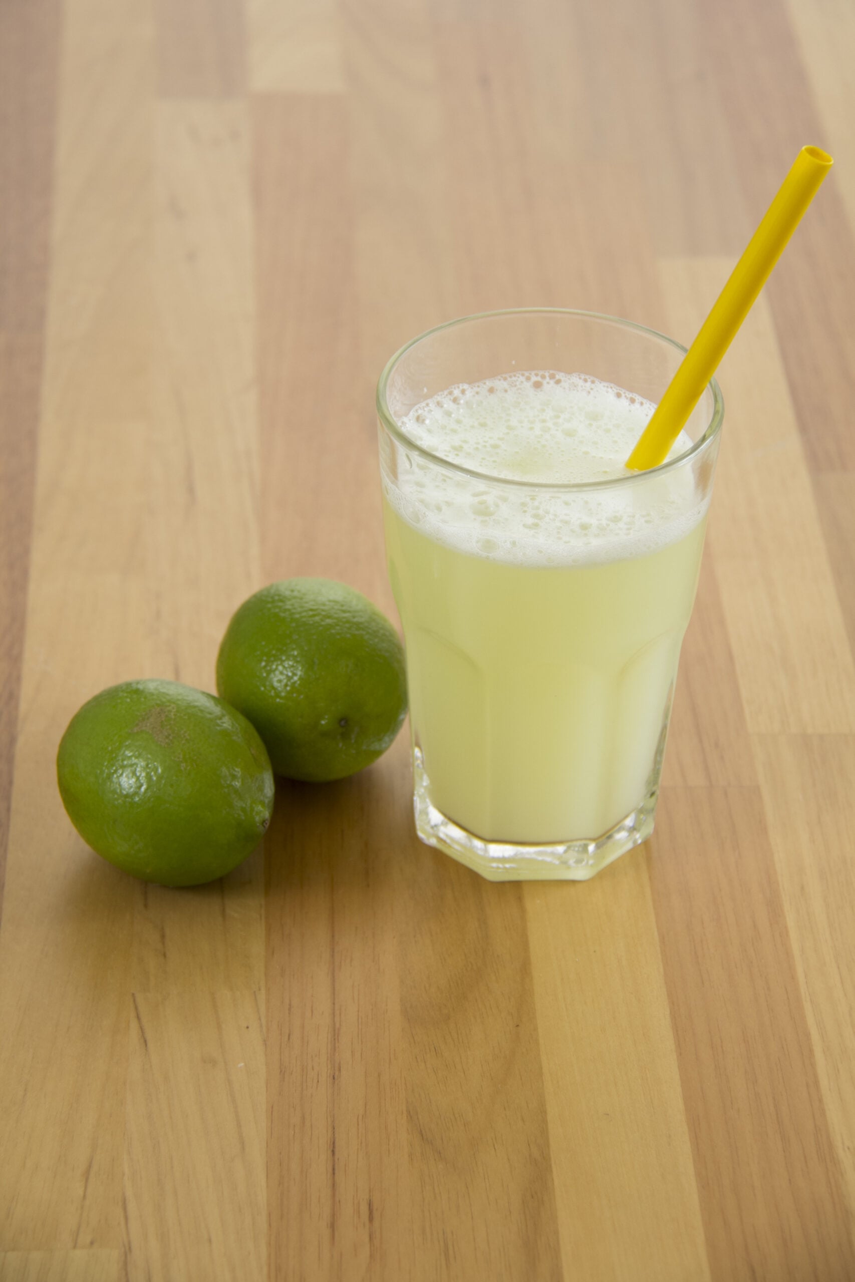 A wooden table showing a homemade quenepas juice. 
