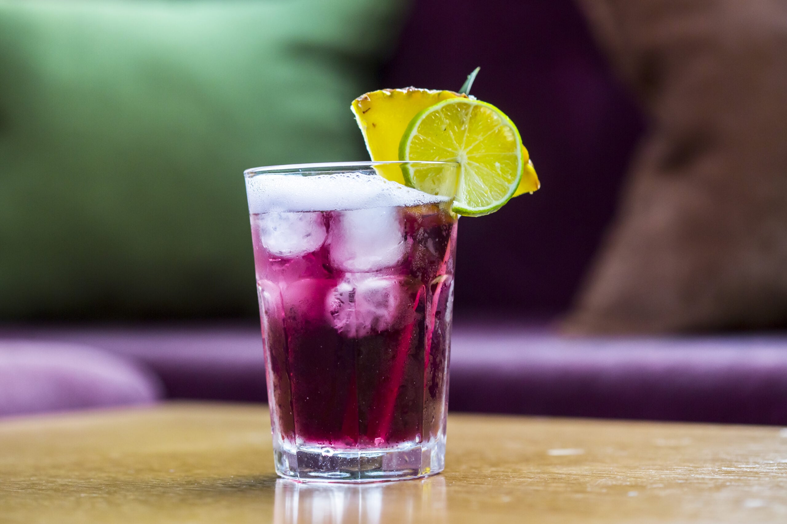 A refreshing purple haze drink resting on a wooden table. 