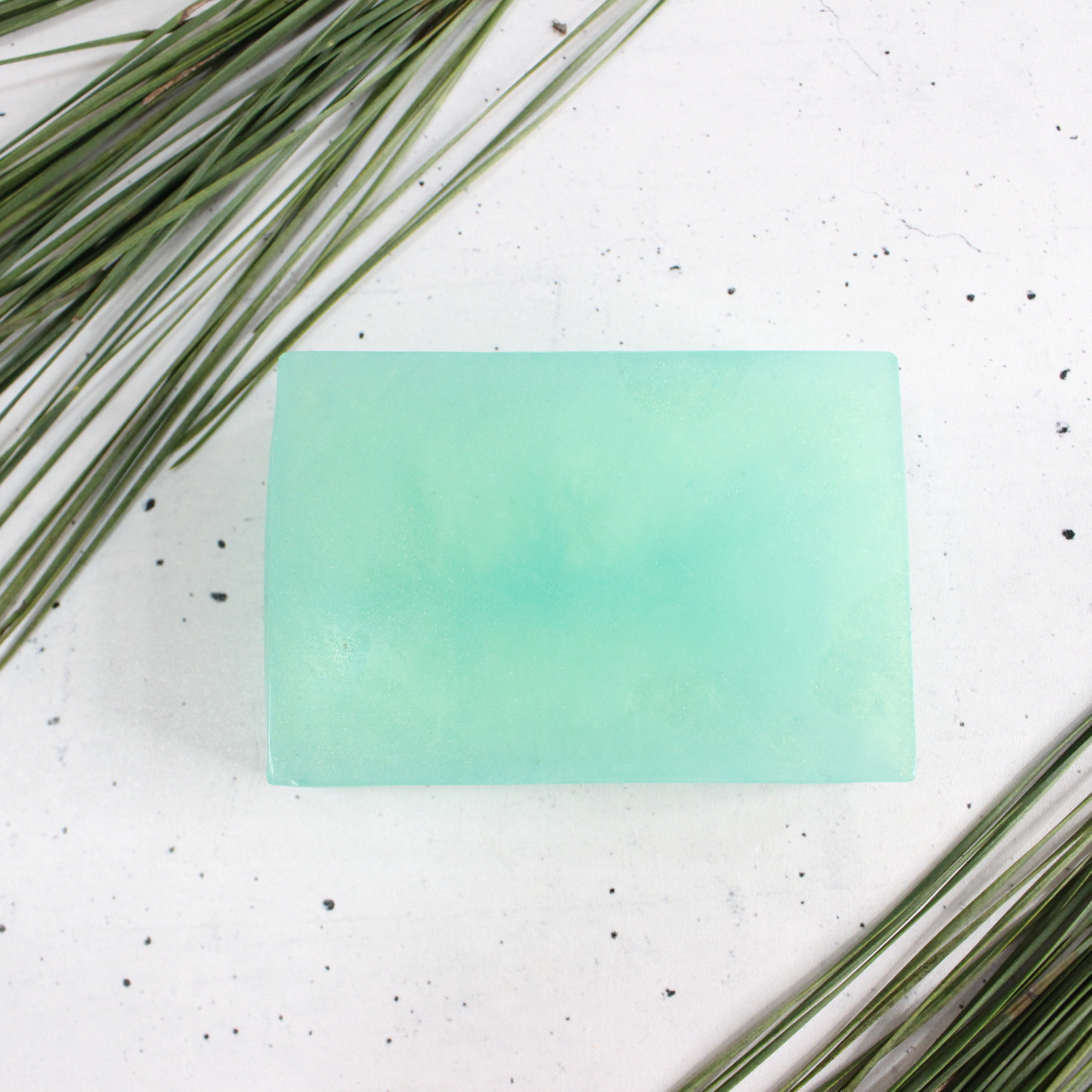 Homemade pine soap next to pine needles.