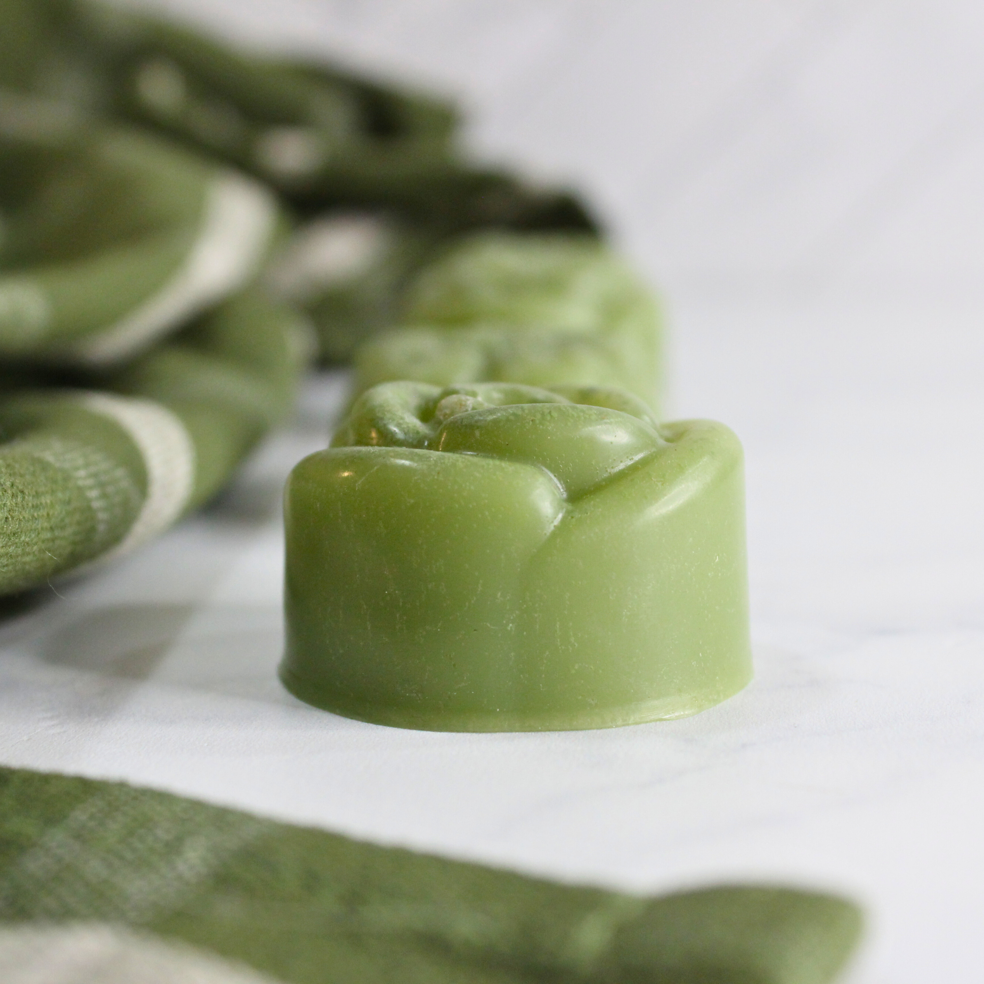 French green clay soap, on a countertop next to a green kitchen towel.