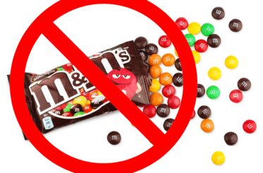 M&Ms bag with M&Ms spilling out, all with a superimposed red "cancel" symbol over them
