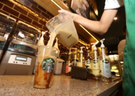 Barista pouring milk into a drink at Starbucks