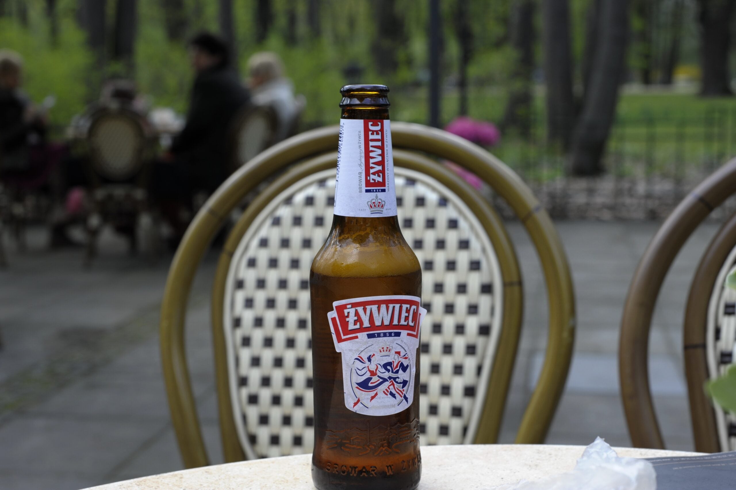 An open bottle of a Żywiec beer on a table. 