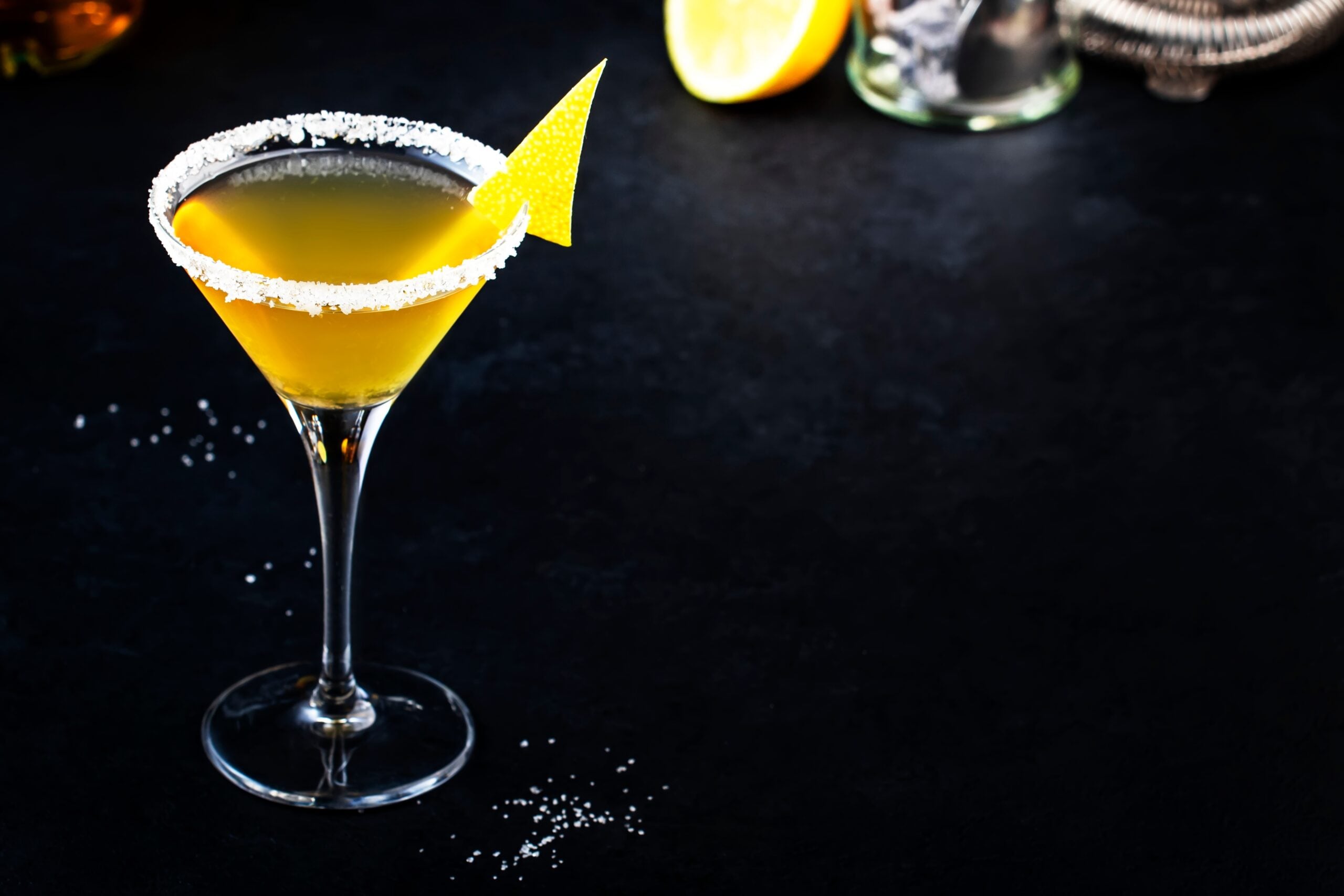 A freshly prepared Yellow Bird cocktail on a black countertop. 