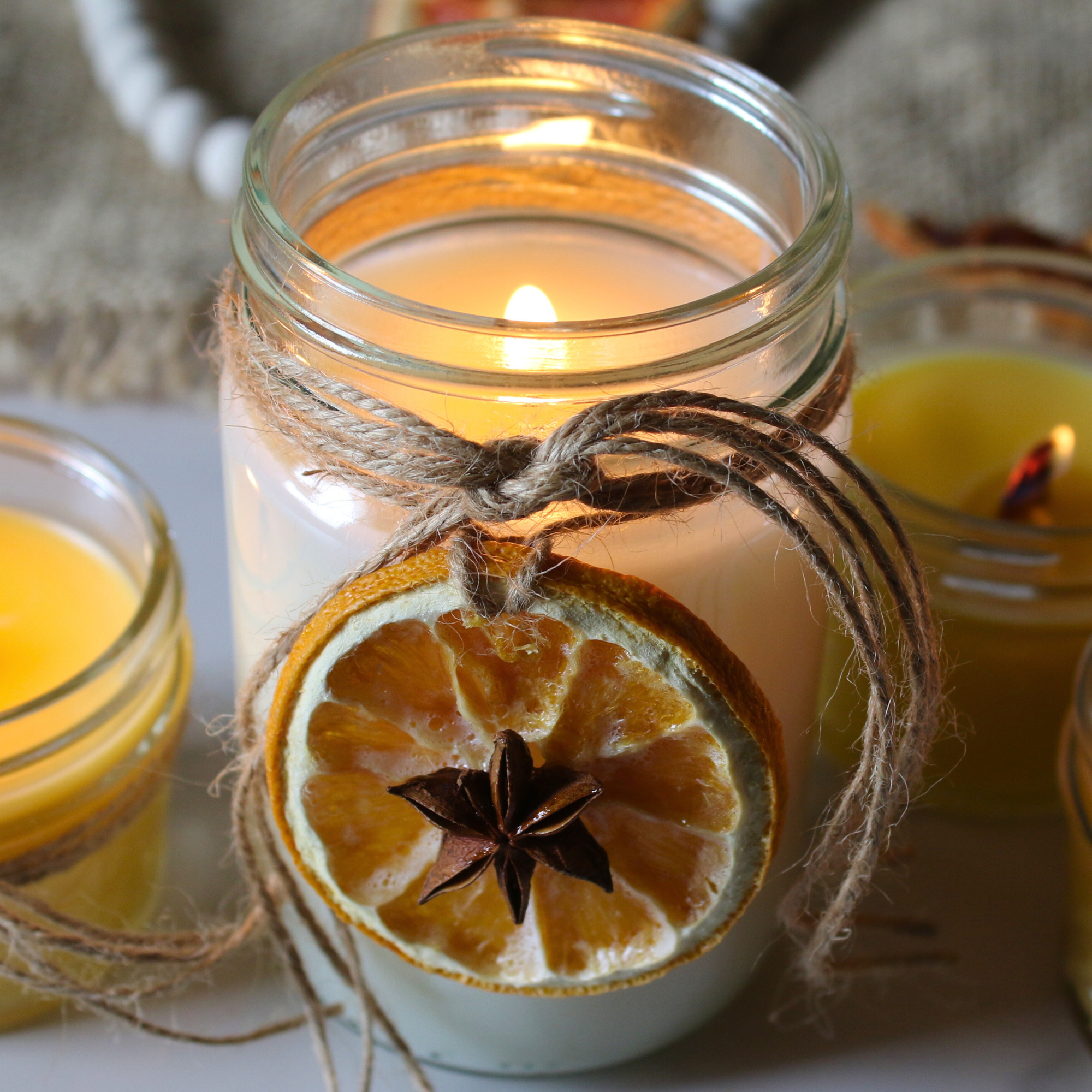 Mason jar candles decorated with twin and lit.