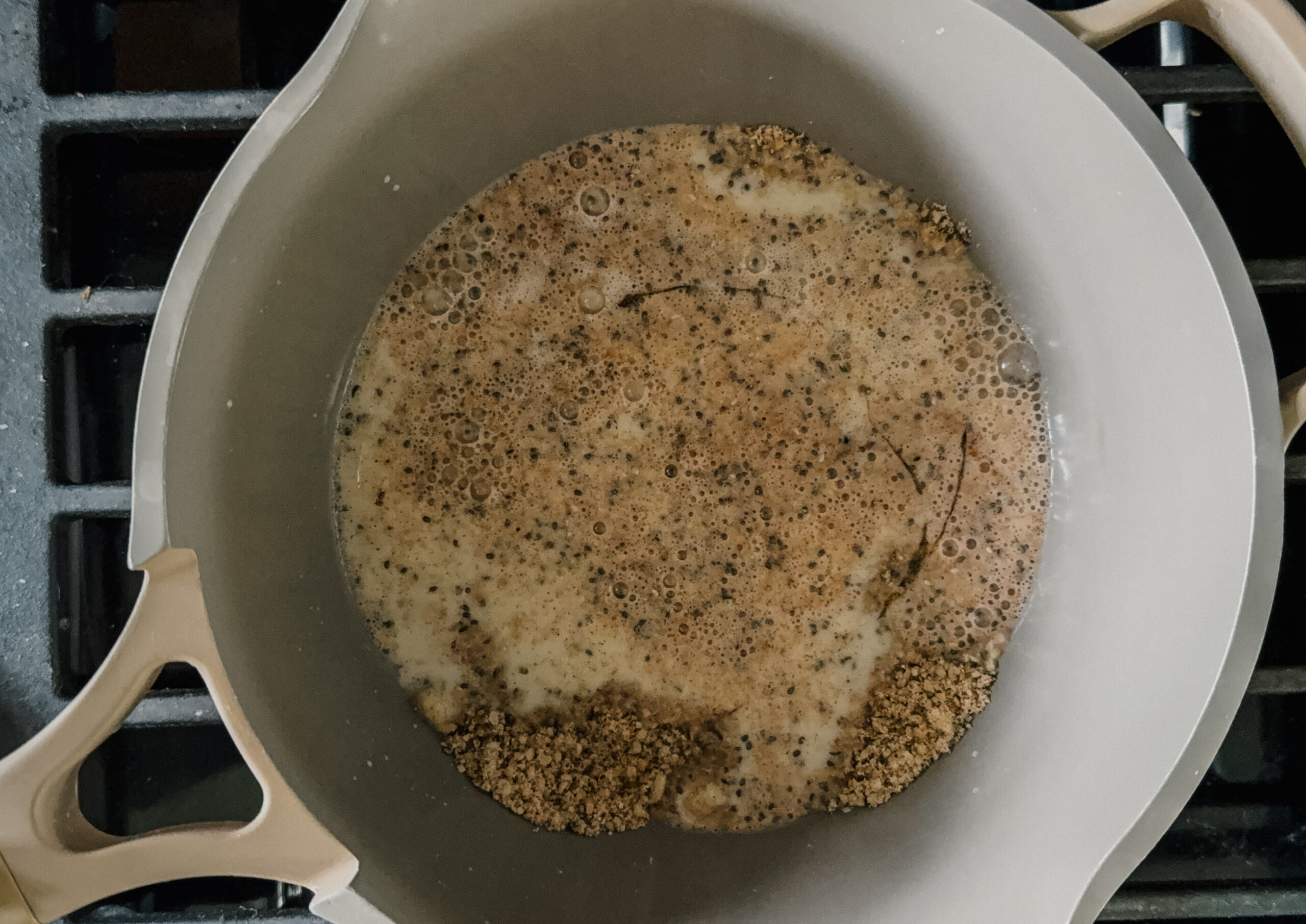 A pot on a stove cooking oatmeal.