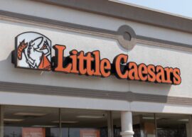 Little Caesars logo and sign on building exterior.