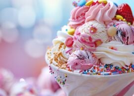 Ice cream sundae with pink and white ice cream and tons of sprinkles and toppings