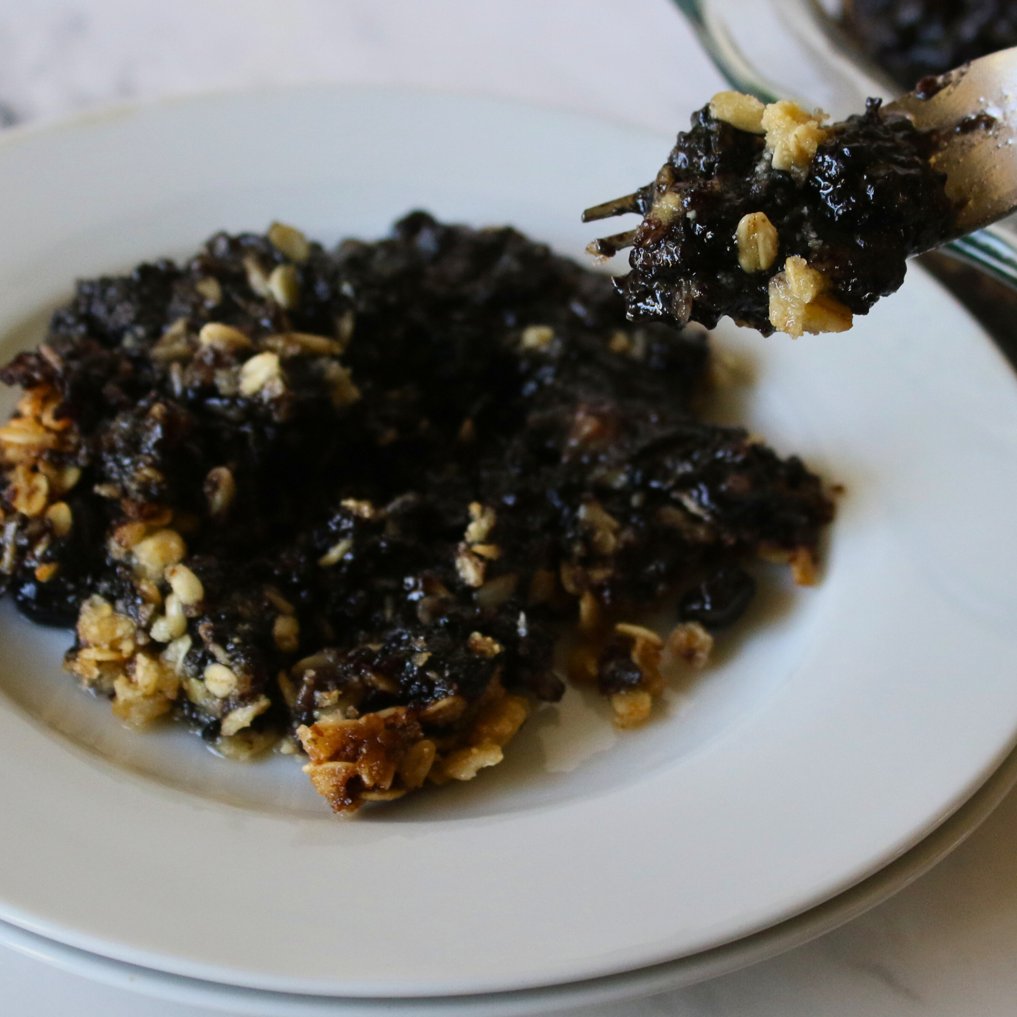 Blueberry crumble on a white plate.