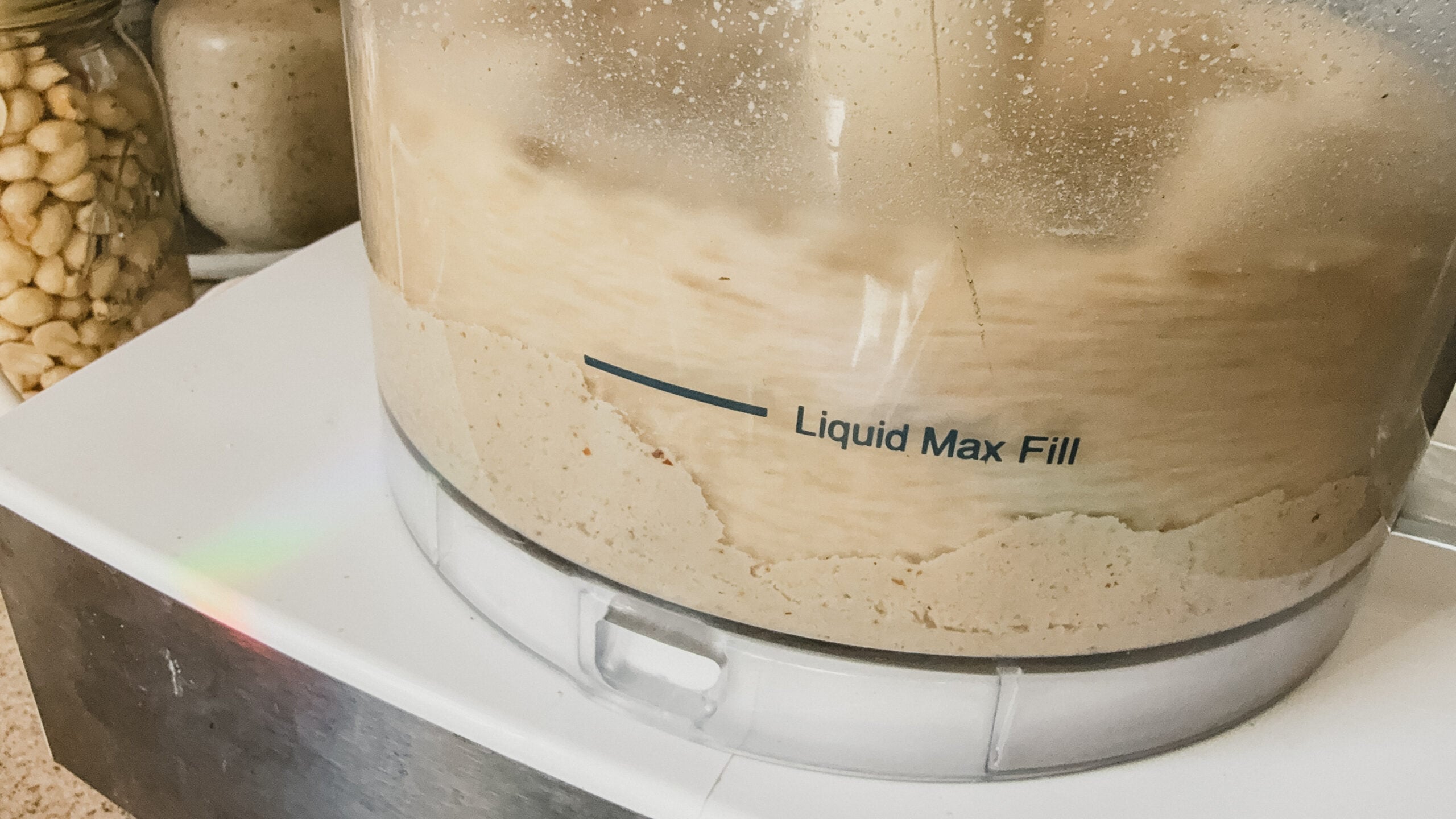 Peanuts being ground into peanut butter in a food processor.